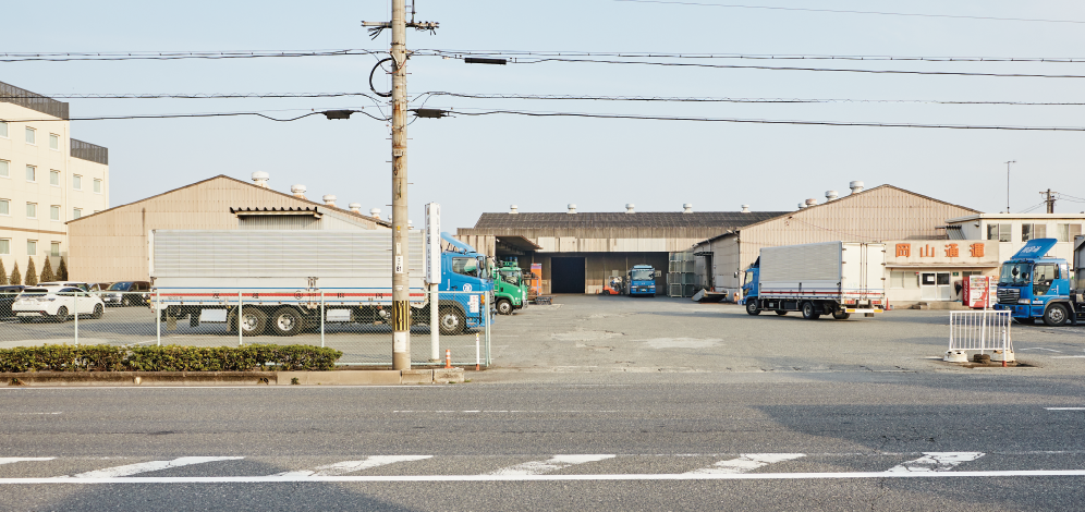 工場の外観とトラックが停車している写真